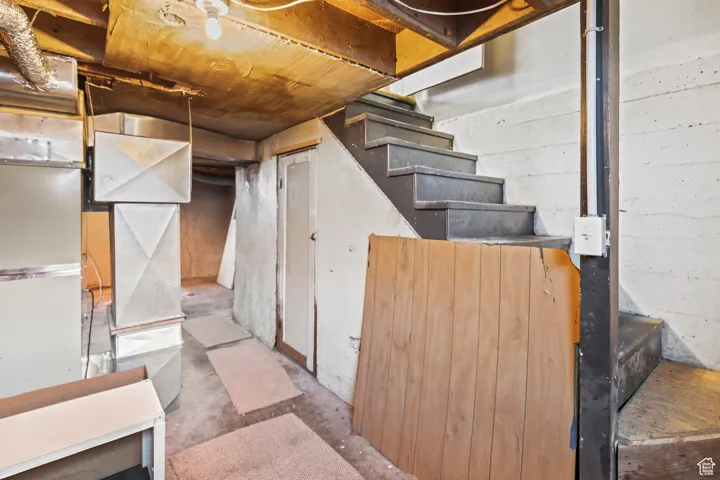 Unfinished below grade area featuring stairway