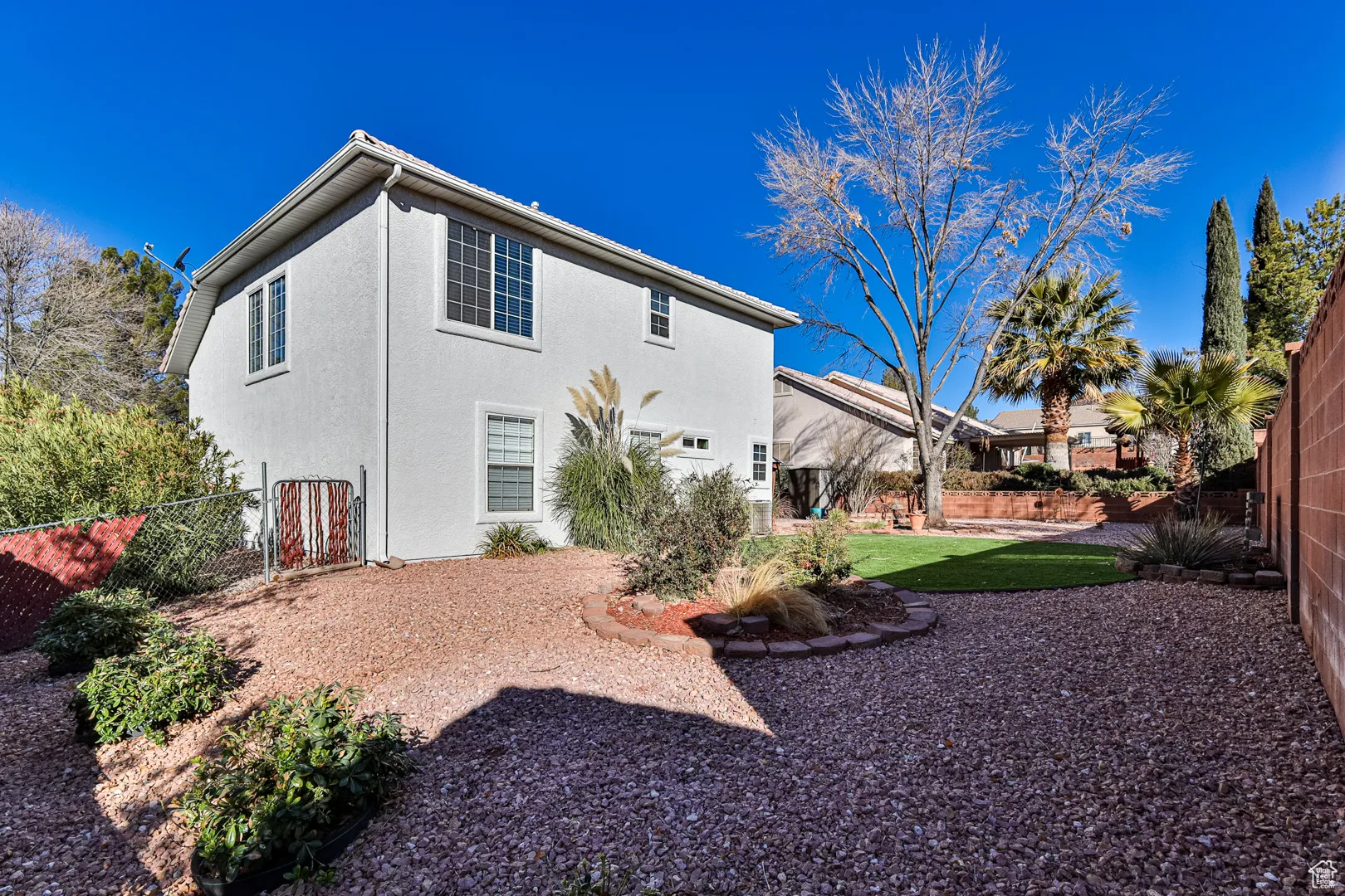 Back of property featuring stucco siding and a fenced backyard
