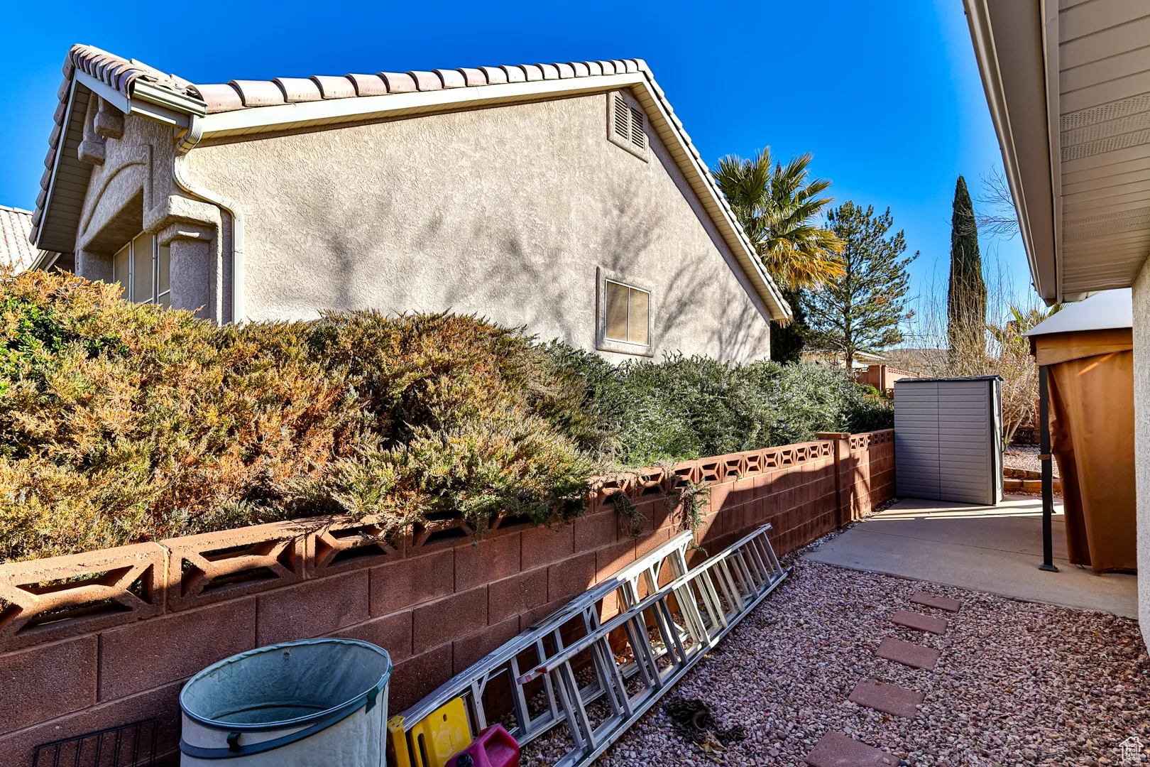 View of property exterior featuring stucco siding, a patio area, and fence