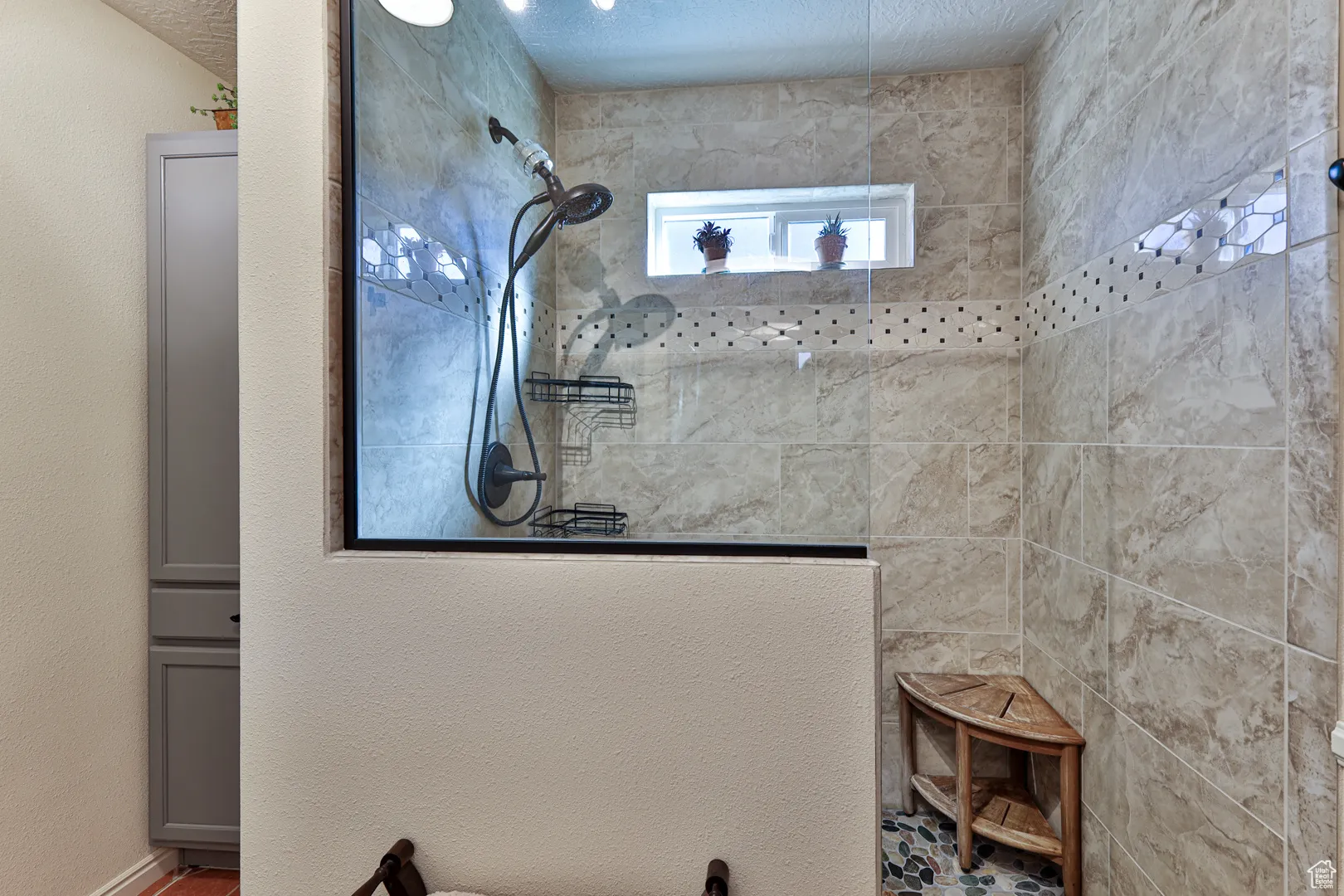 Bathroom with a textured ceiling and a walk in shower