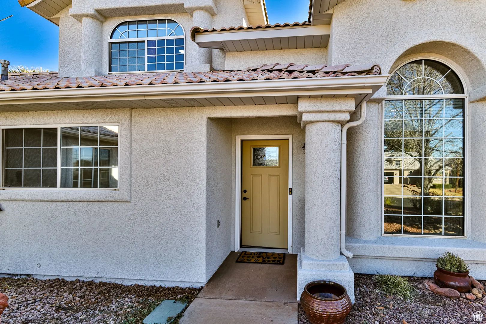 Doorway to property featuring stucco siding and a tile roof