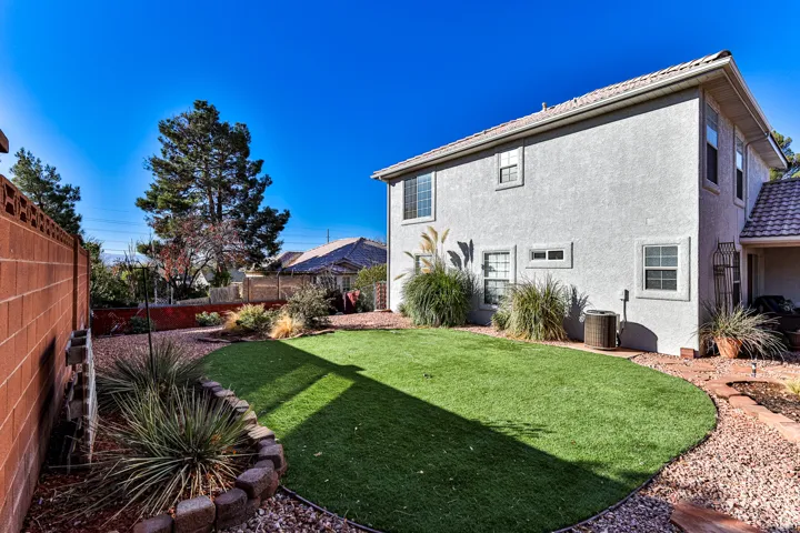 View of yard with central AC and fence
