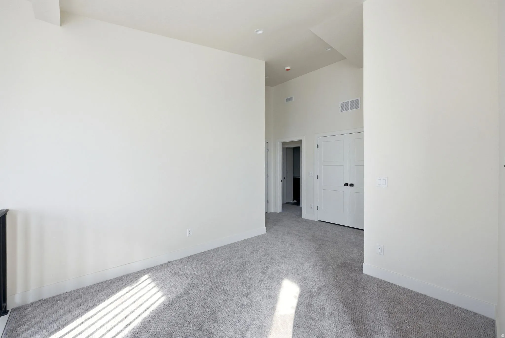 Spare room with a high ceiling and carpet flooring