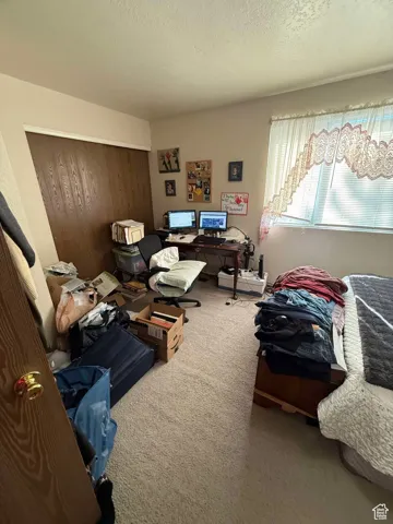 Carpeted bedroom featuring a closet and a textured ceiling