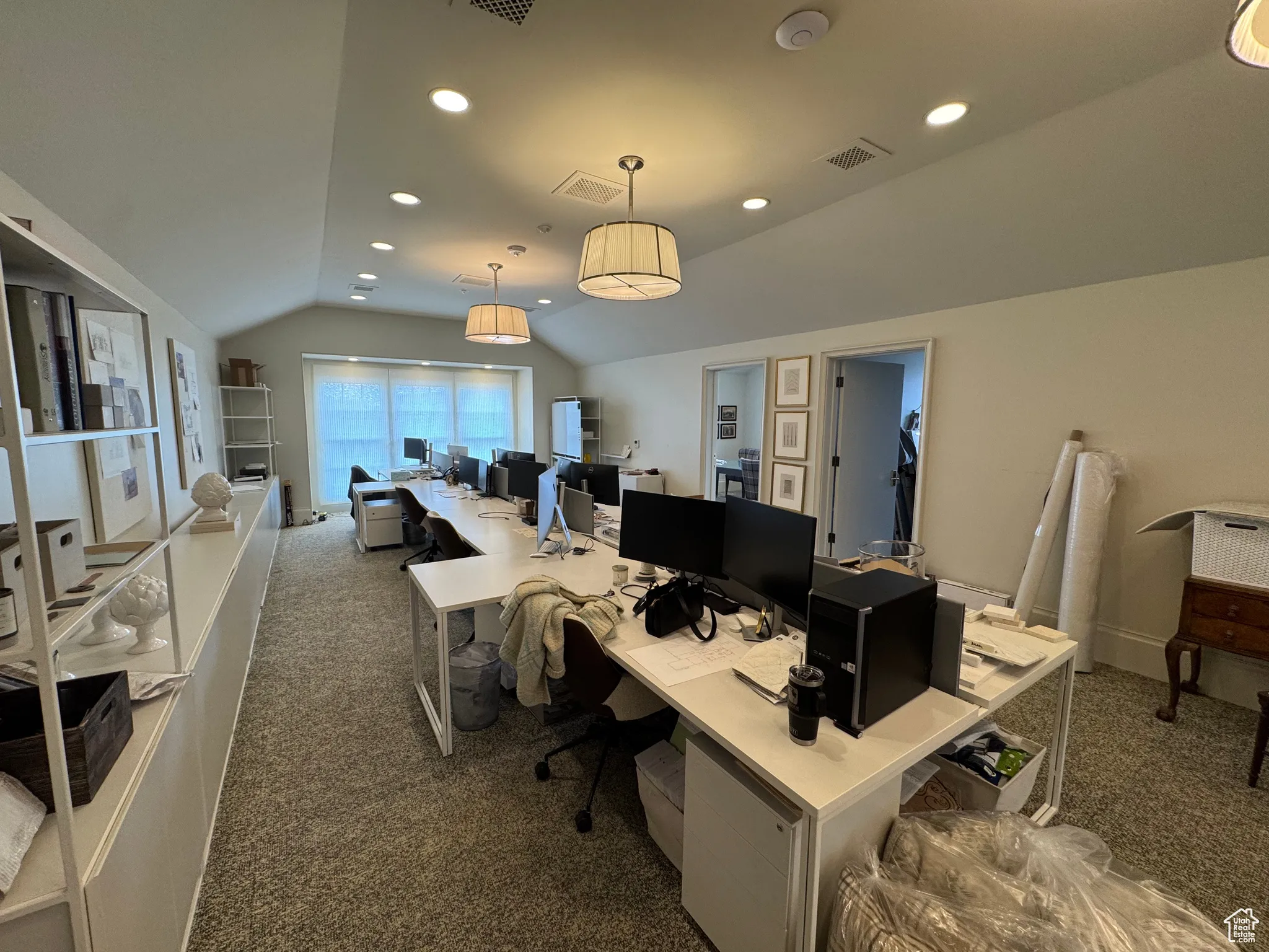 Carpeted office with vaulted ceiling, recessed lighting, and visible vents