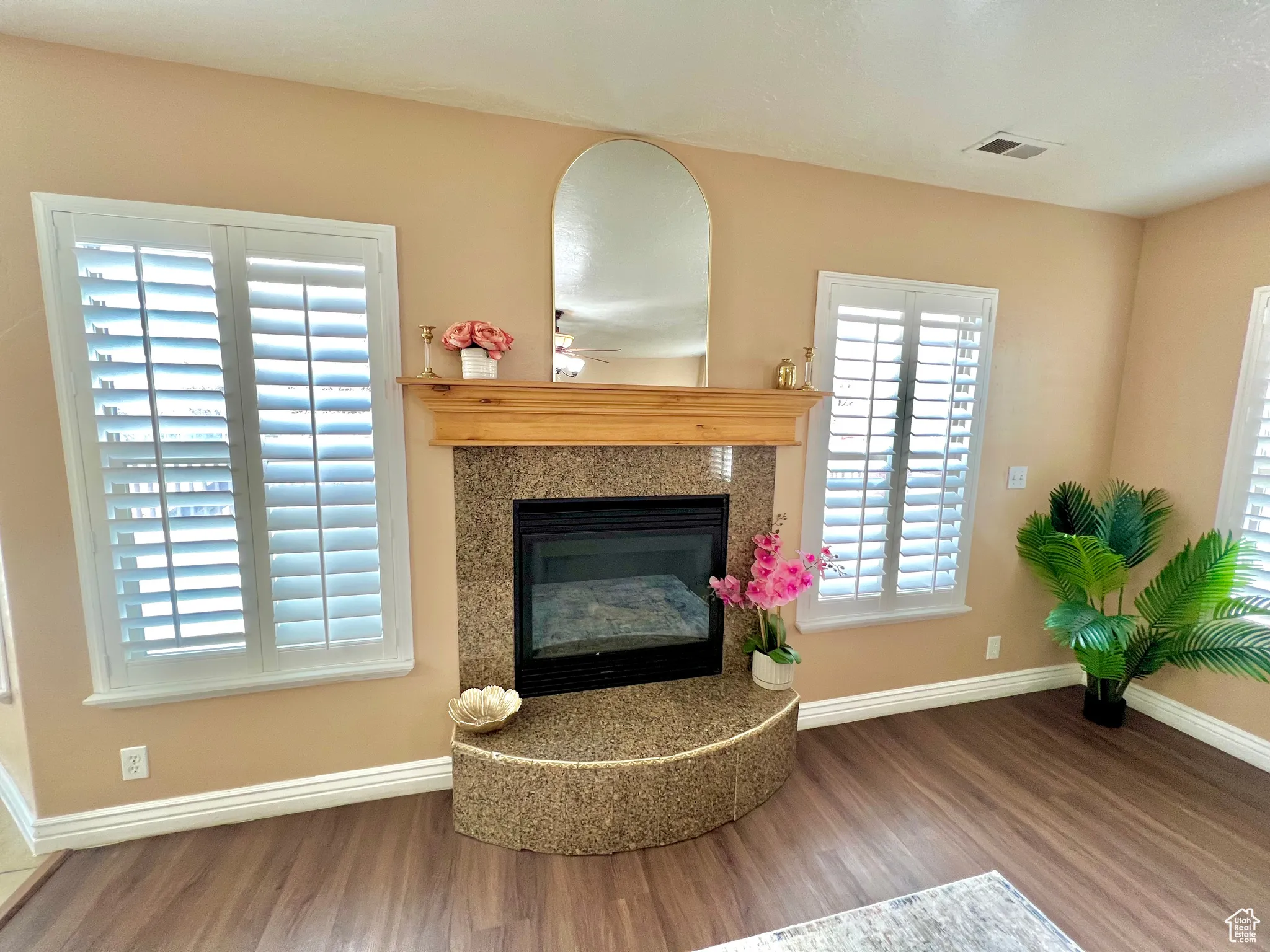 Interior details featuring a premium fireplace, wood finished floors, visible vents, and baseboards