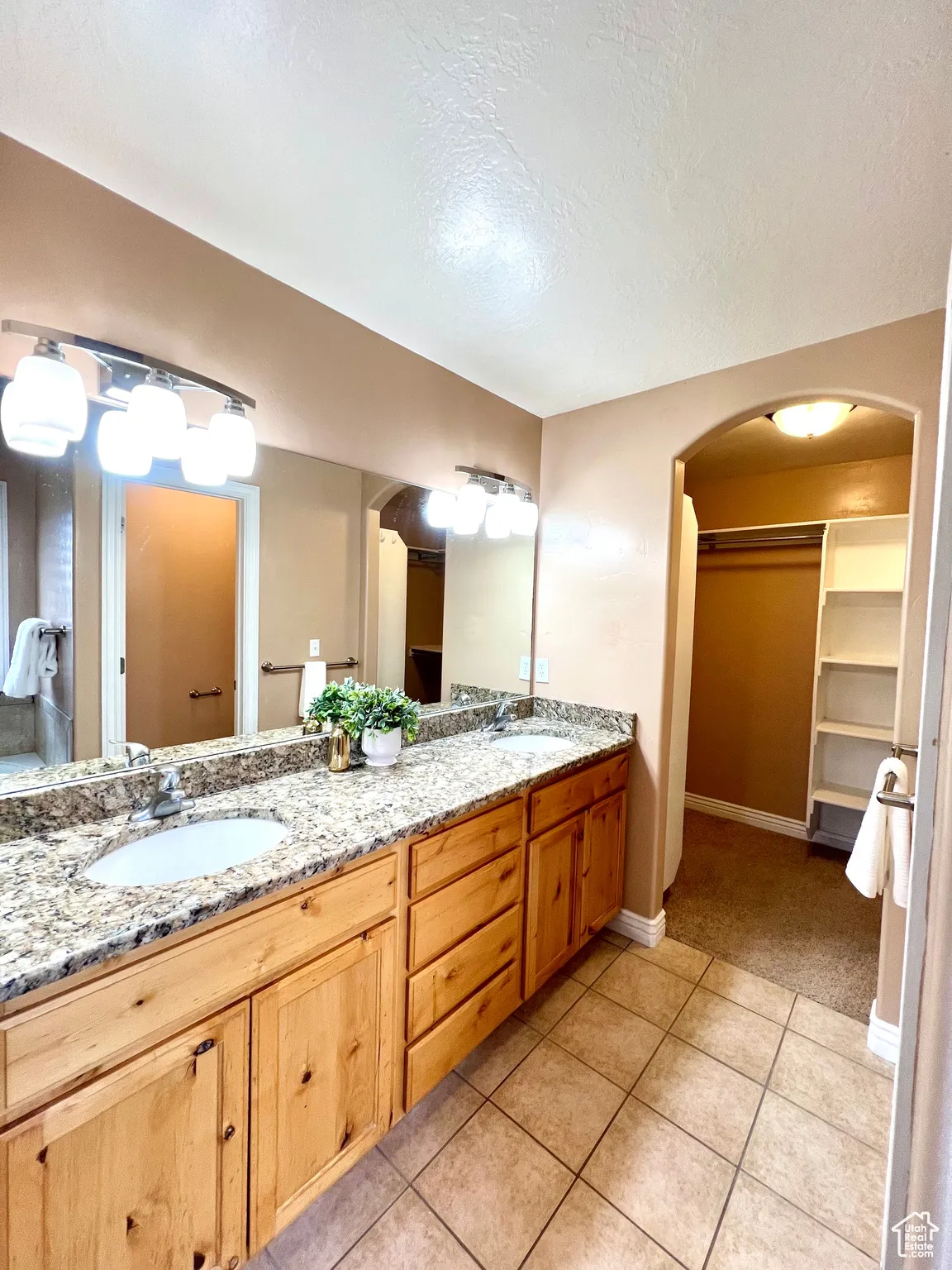 Bathroom featuring a sink, a spacious closet, double vanity, and tile patterned flooring