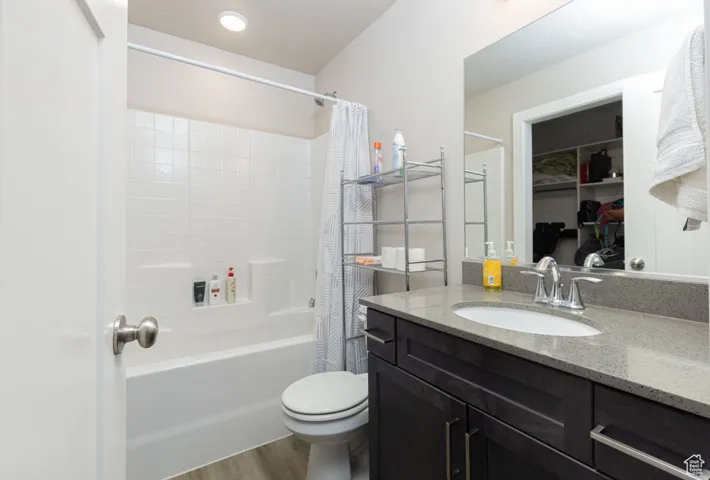 Bathroom with shower / tub combo with curtain, toilet,  and vanity