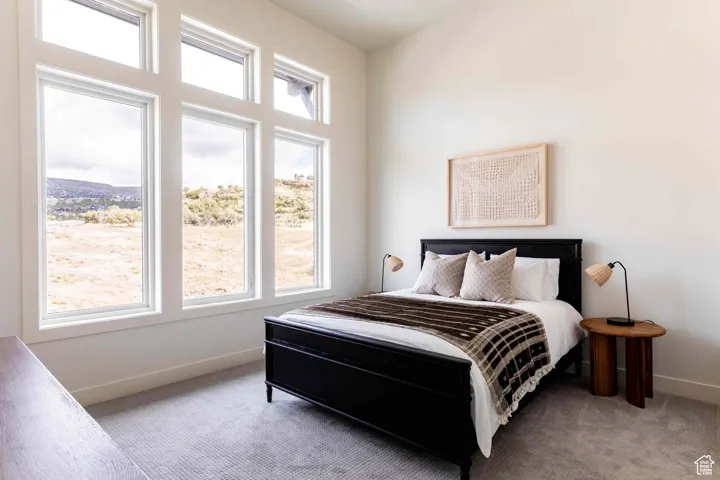 Bedroom featuring baseboards and light carpet