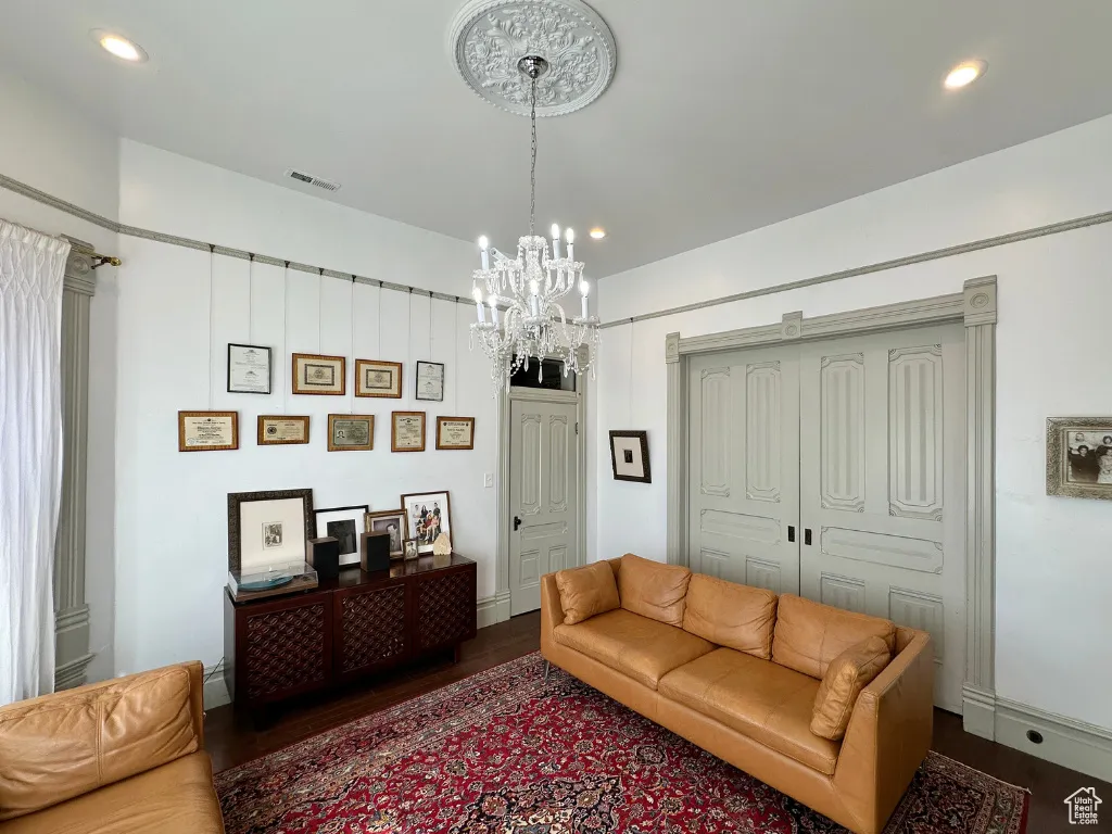 Living room with recessed lighting, visible vents, a notable chandelier, and dark wood-style flooring