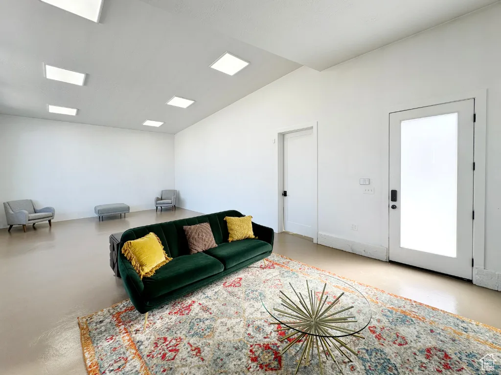 Living area with vaulted ceiling and finished concrete floors