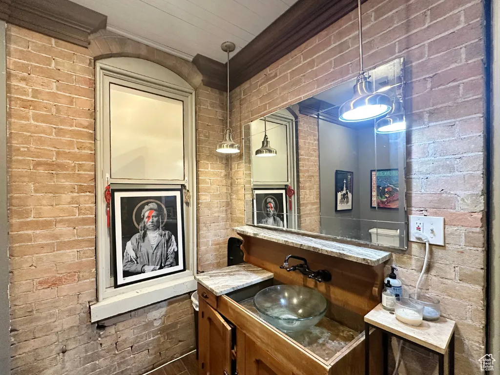 Bathroom with brick wall and ornamental molding