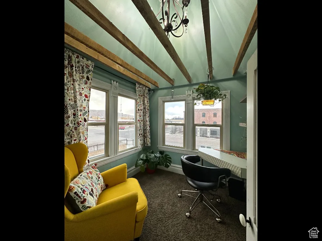 Carpeted office featuring vaulted ceiling with beams and baseboards