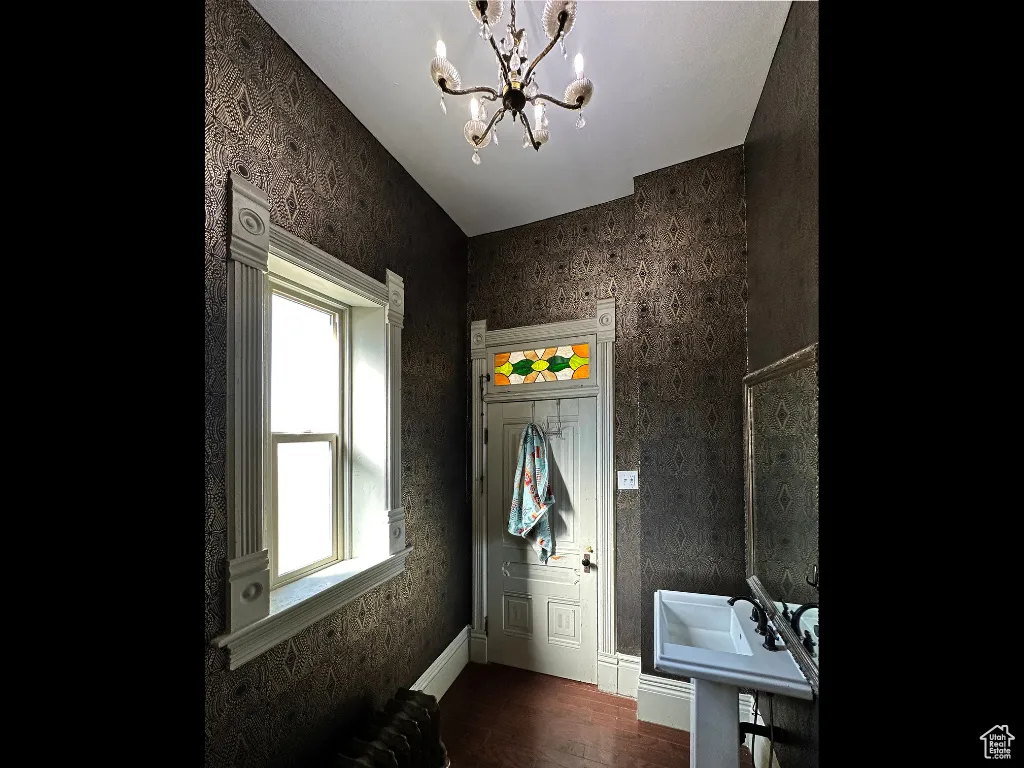 Bathroom featuring a chandelier, radiator heating unit, baseboards, and wood finished floors