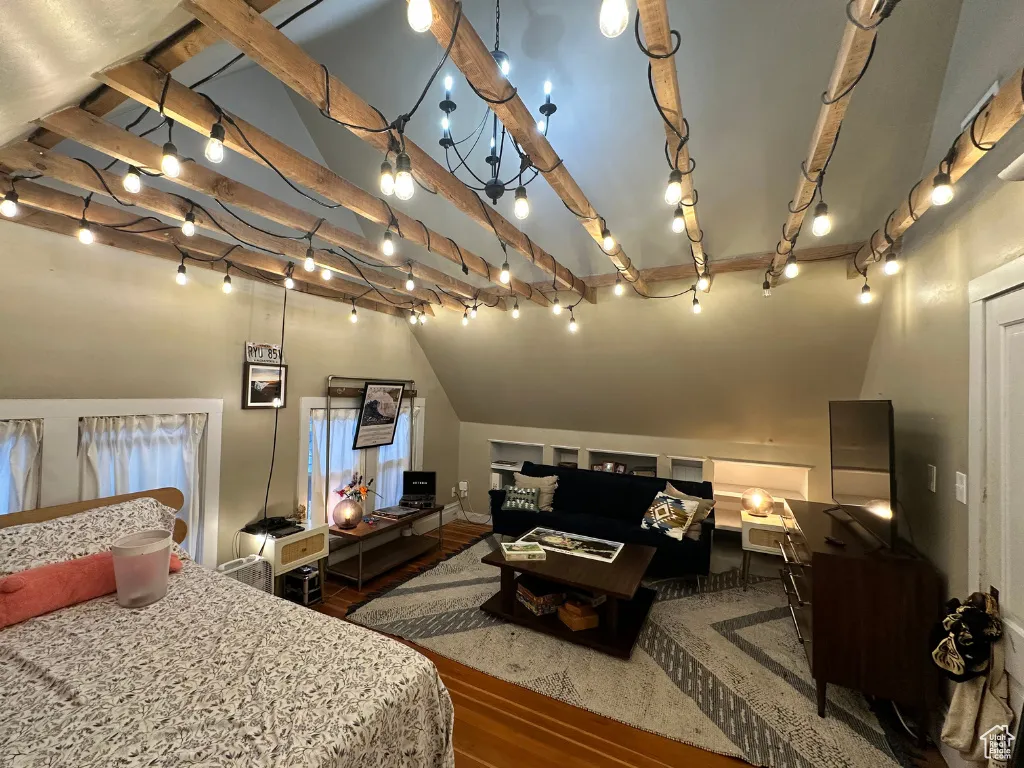 Bedroom featuring track lighting, lofted ceiling with beams, and wood finished floors