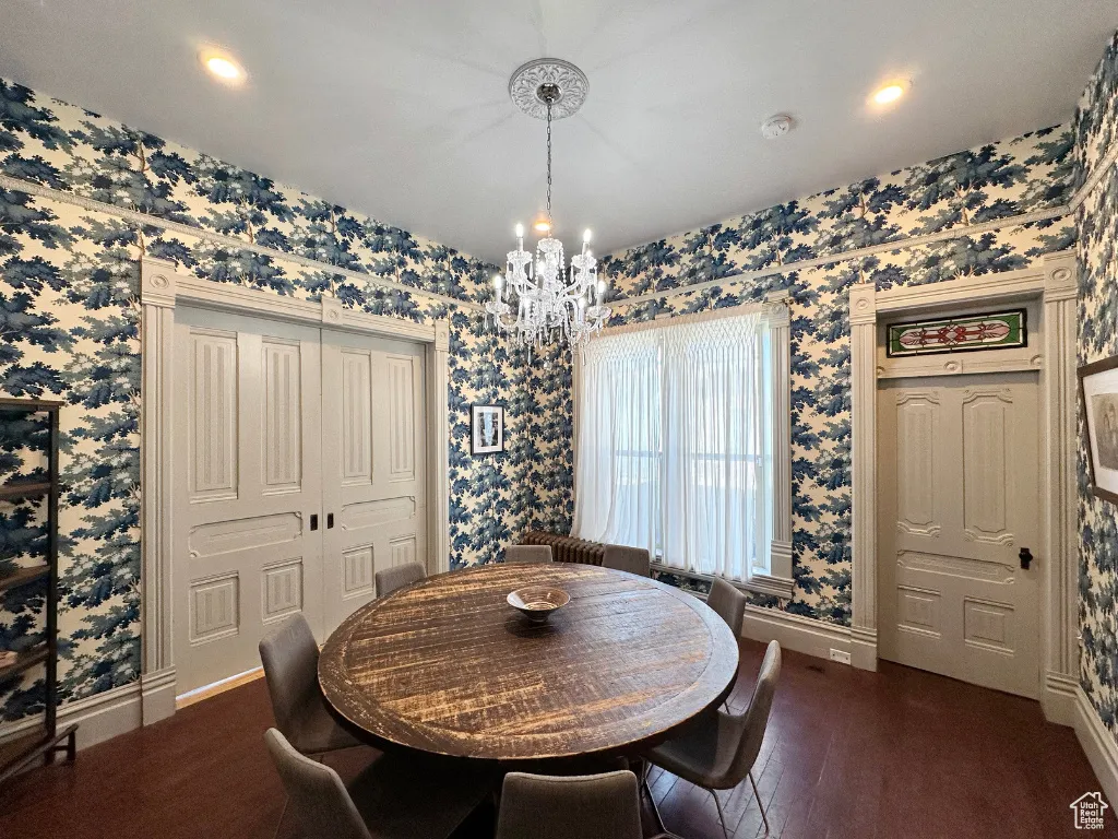 Dining room featuring baseboards, a notable chandelier, and wallpapered walls