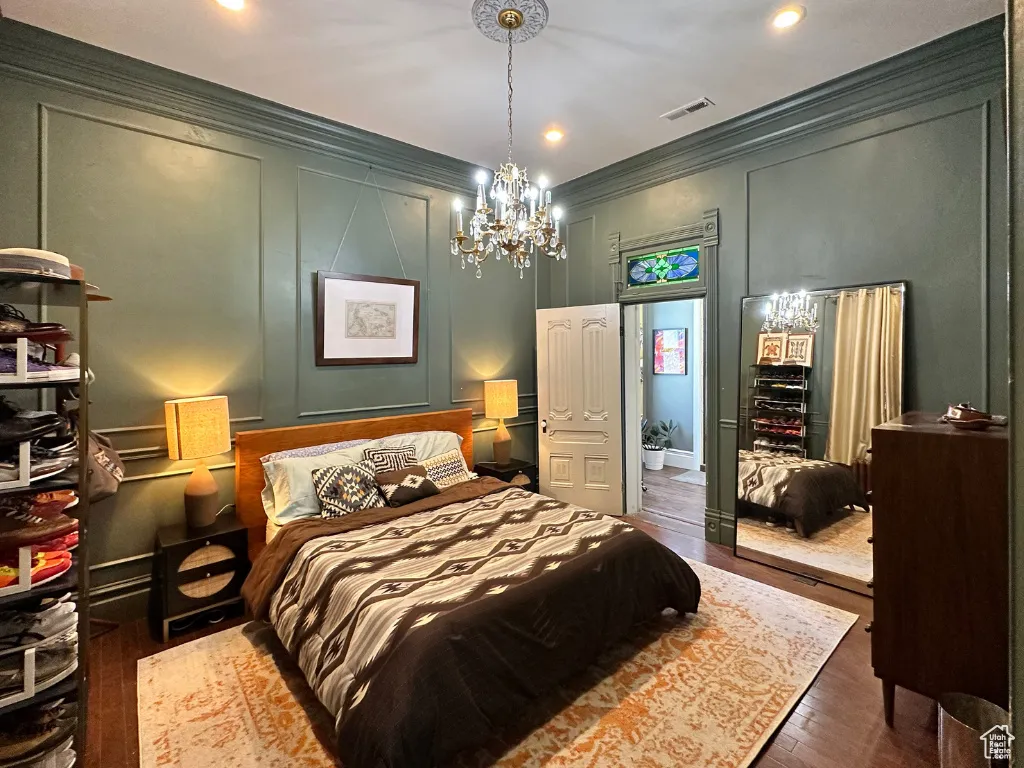 Bedroom with crown molding, a decorative wall, and visible vents