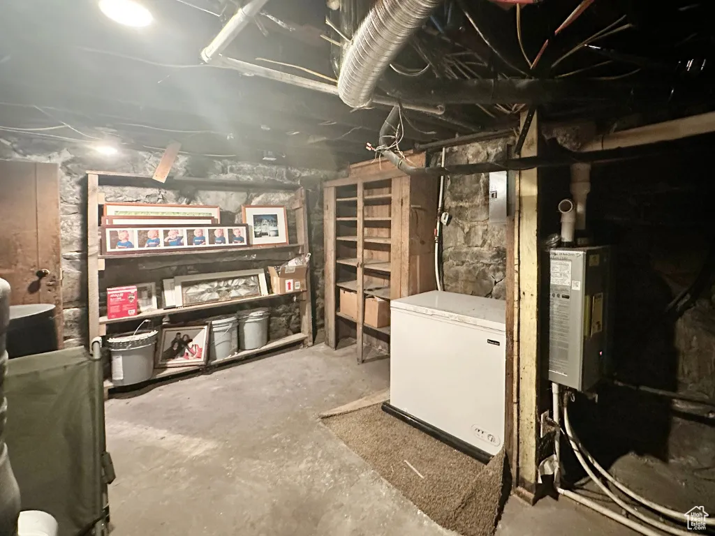 Unfinished below grade area featuring refrigerator