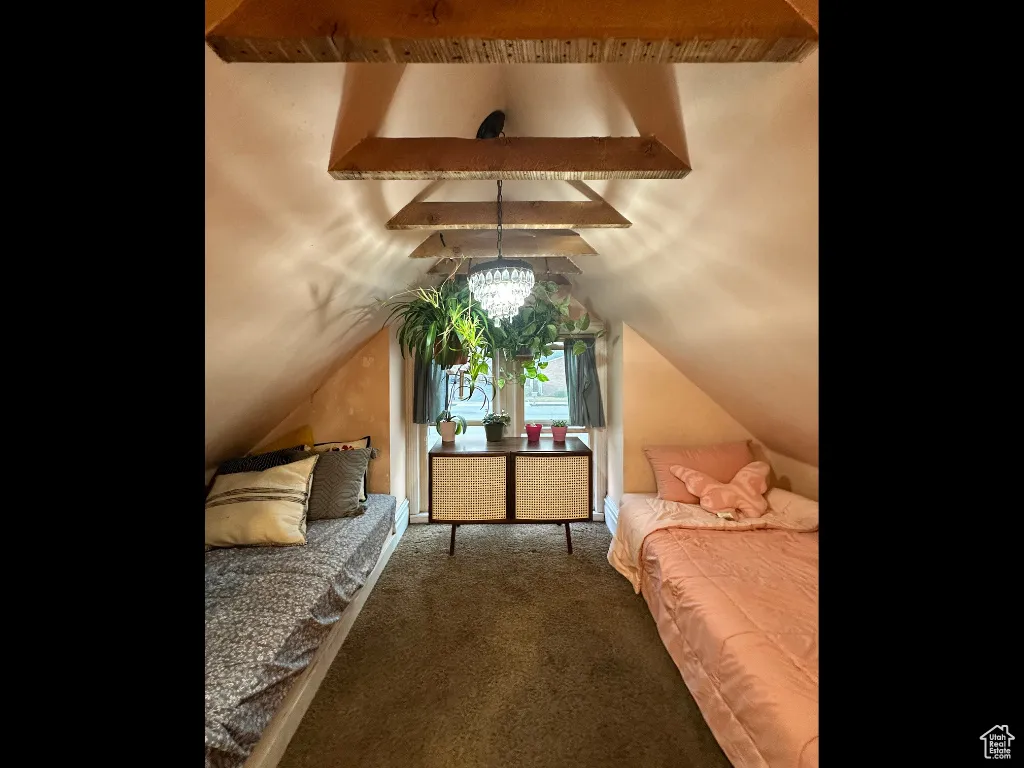 Bedroom with access to exterior, vaulted ceiling with beams, and carpet