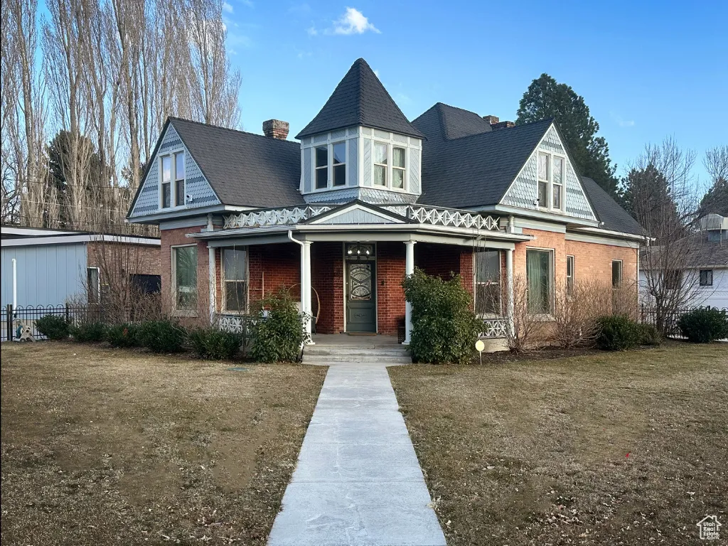 View of front of house with brick siding and covered porch