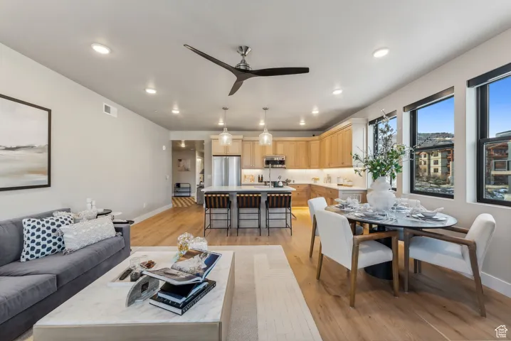 Living area featuring visible vents, a ceiling fan, recessed lighting, light wood-style floors, and baseboards