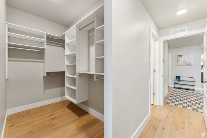 Spacious closet featuring visible vents and hardwood / wood-style flooring