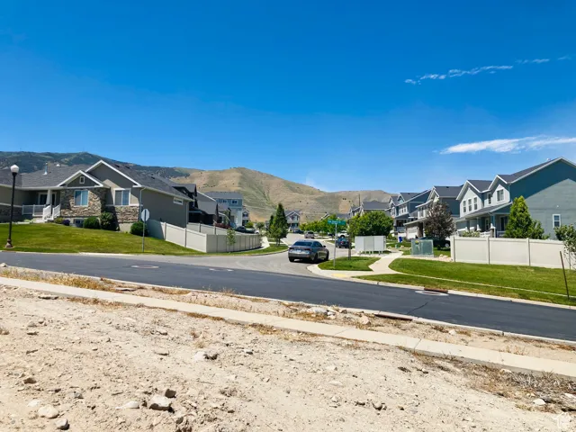 View of road with a residential view, a mountain view, street lighting, and sidewalks