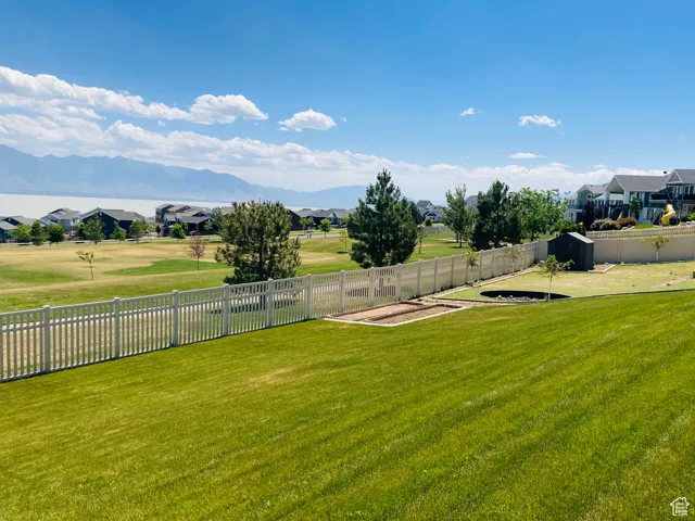 View of yard featuring a mountain view, a fenced backyard, and a residential view