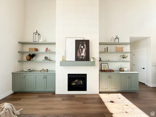 Living area featuring dark wood-style flooring and a tiled fireplace
