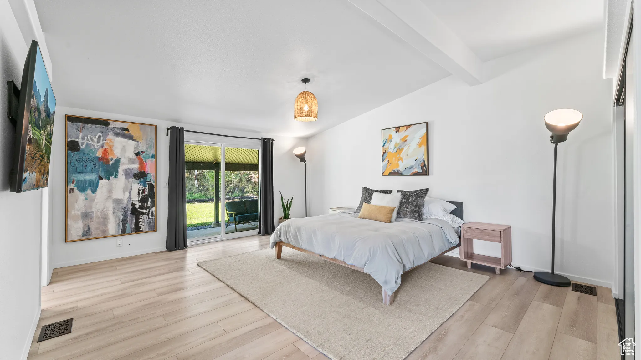 Bedroom featuring visible vents, lofted ceiling with beams, light wood-style floors, and access to outside