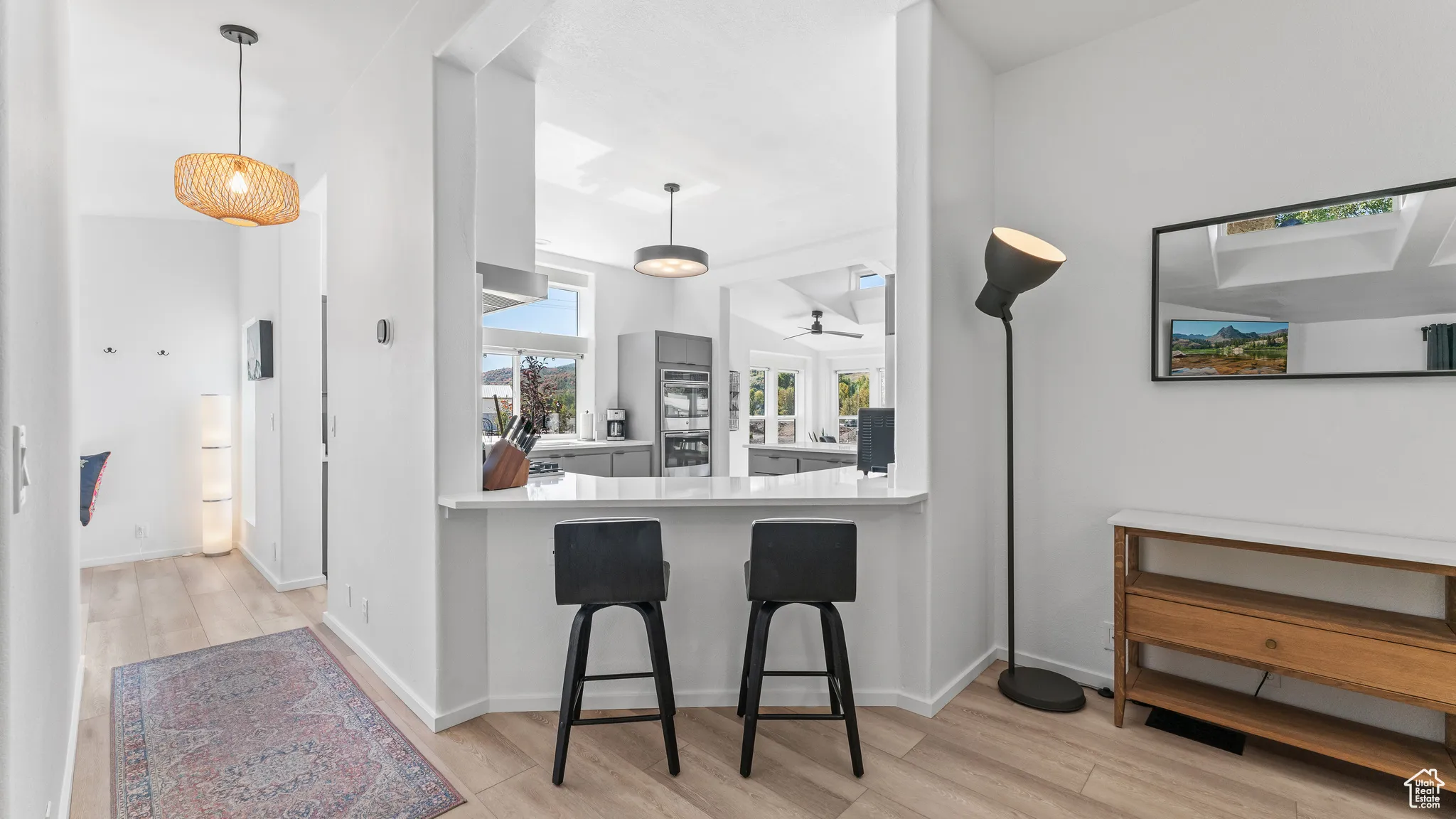 Kitchen with light wood-type flooring, pendant lighting, a breakfast bar area, and light countertops