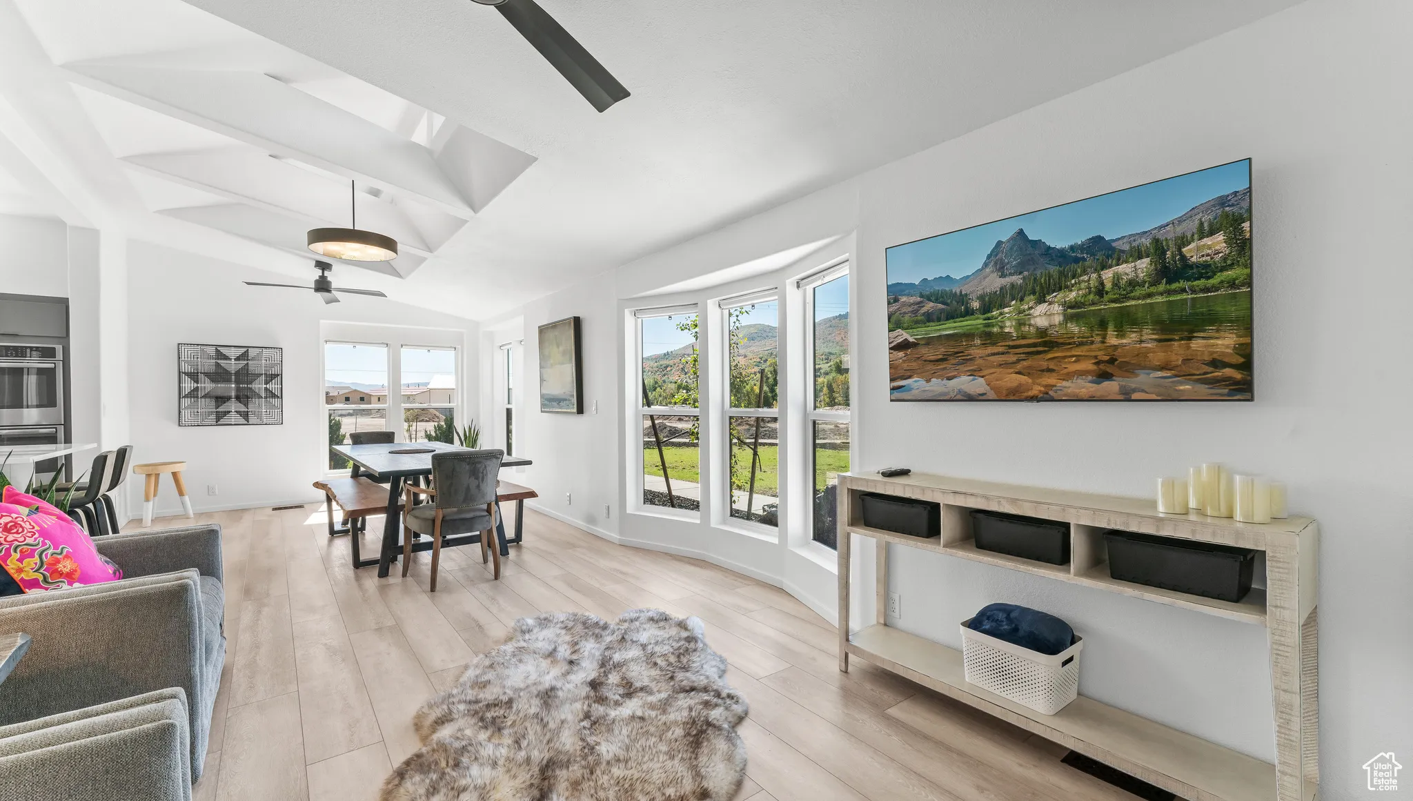 Interior space with lofted ceiling, baseboards, light wood-type flooring, and ceiling fan