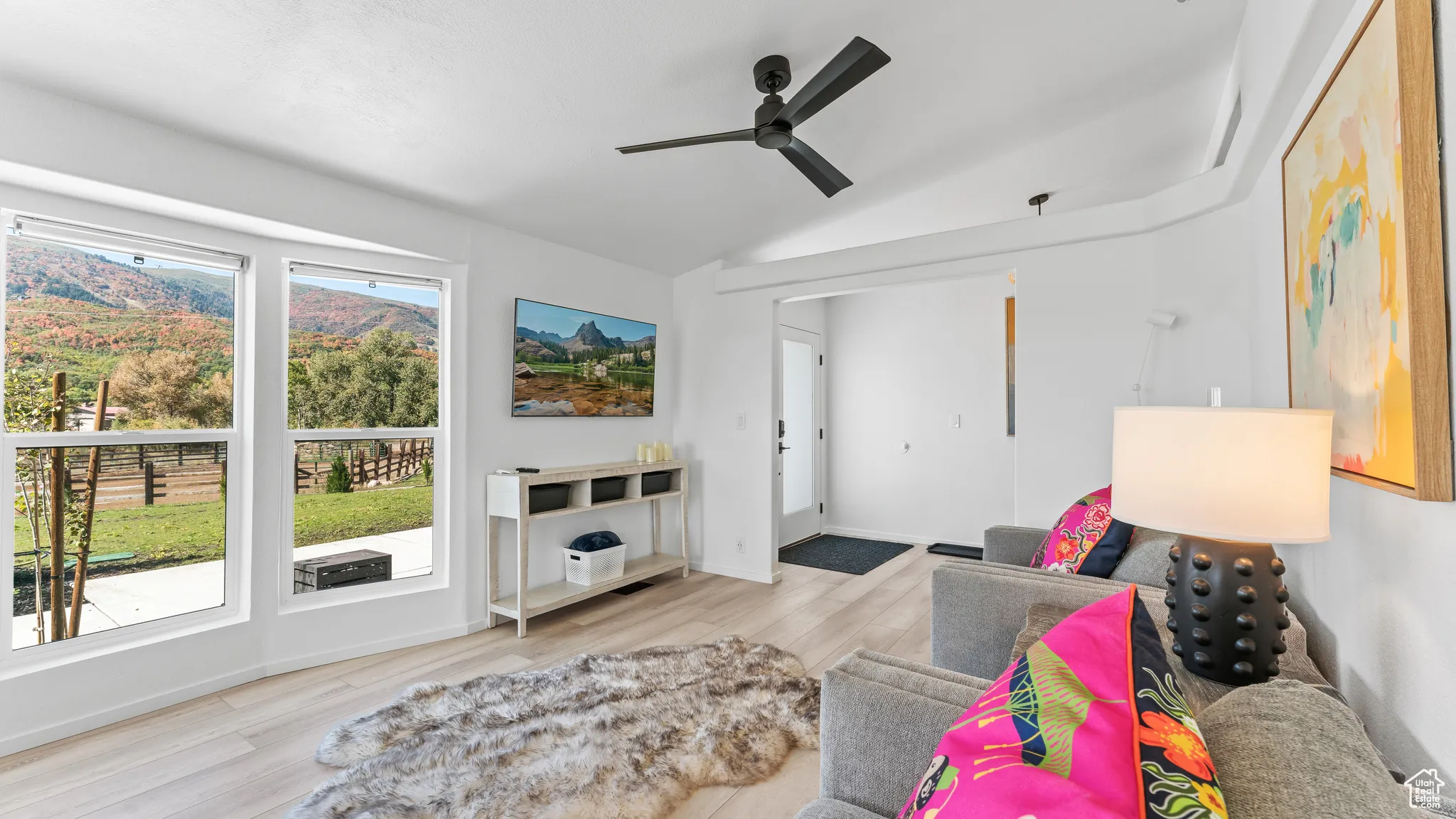 Sitting room with vaulted ceiling, wood finished floors, baseboards, and ceiling fan