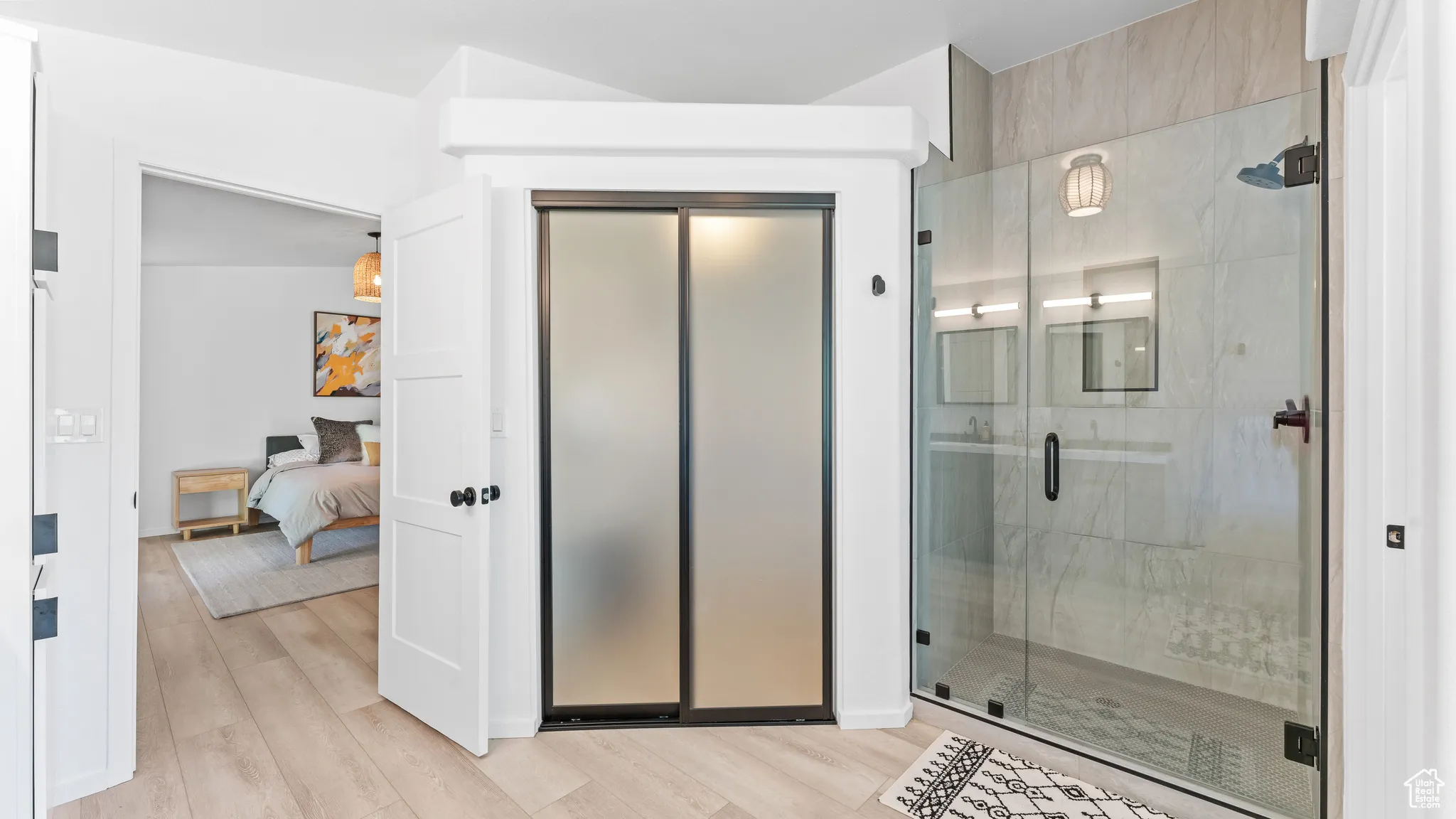 Ensuite bathroom featuring a shower stall, wood finished floors, and ensuite bathroom