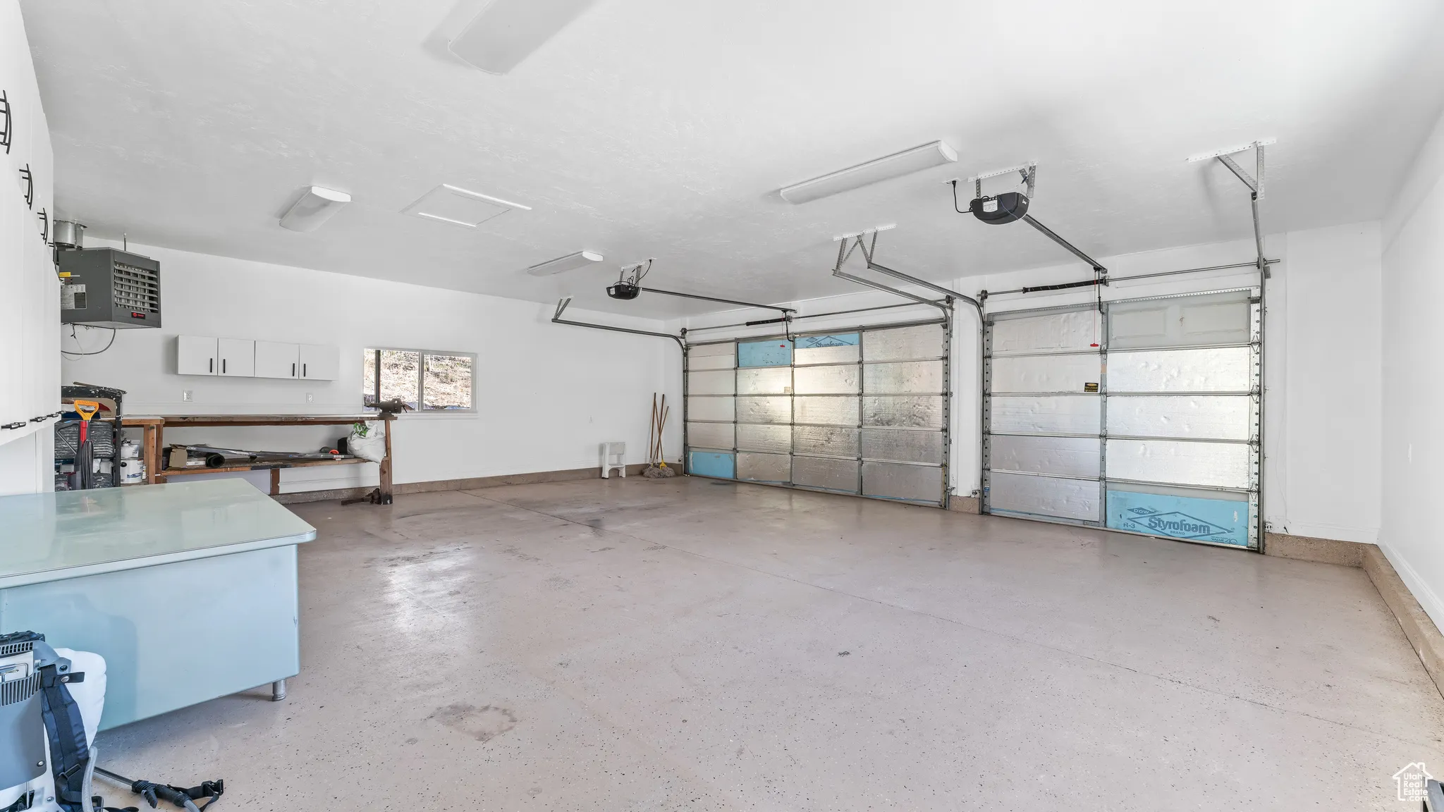 Garage with baseboards and a garage door opener