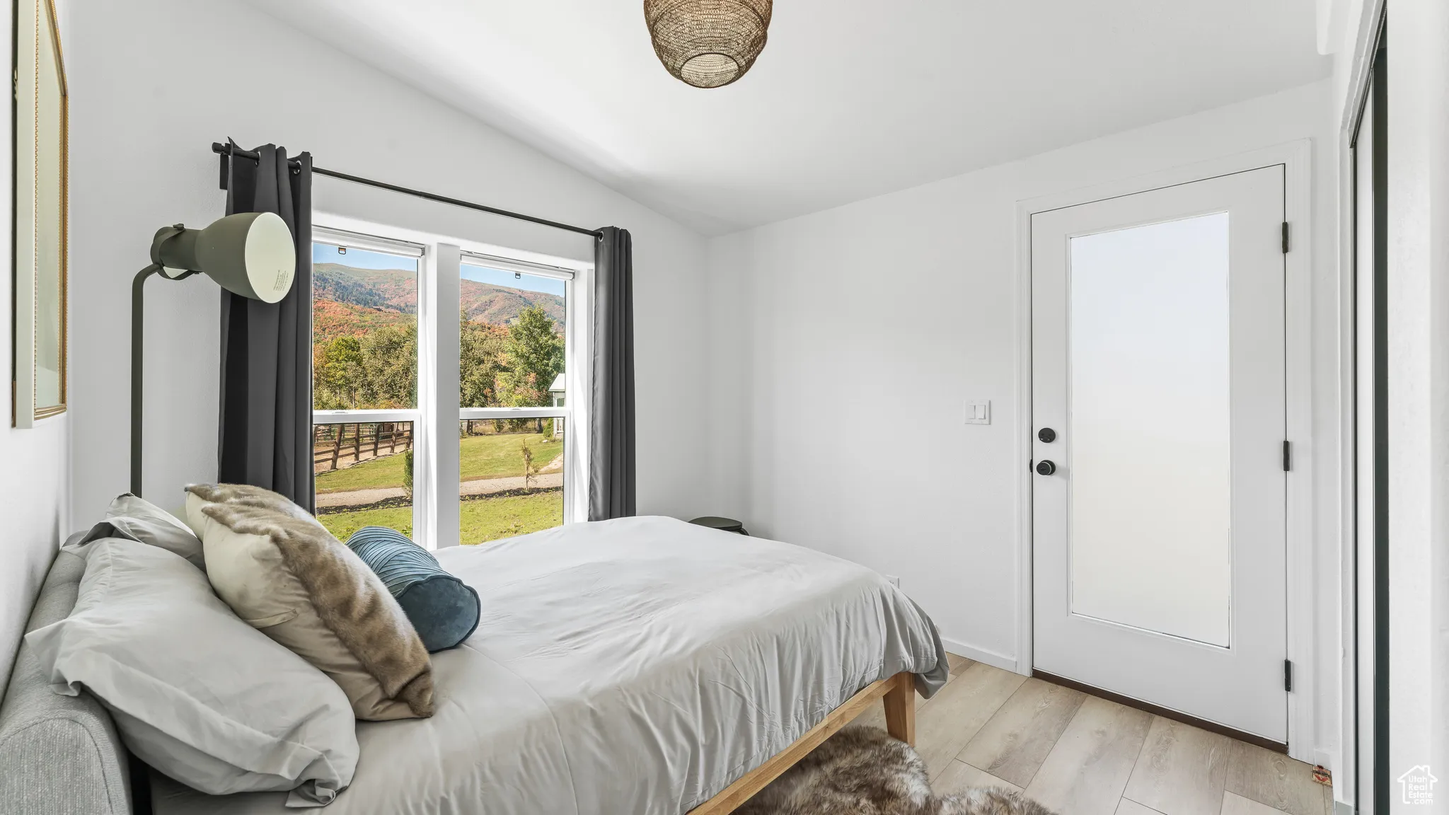Bedroom with light wood-type flooring and vaulted ceiling
