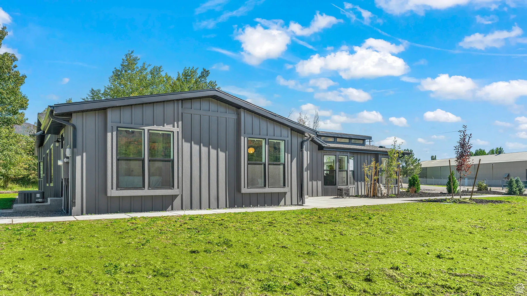 Rear view of property with a lawn and board and batten siding