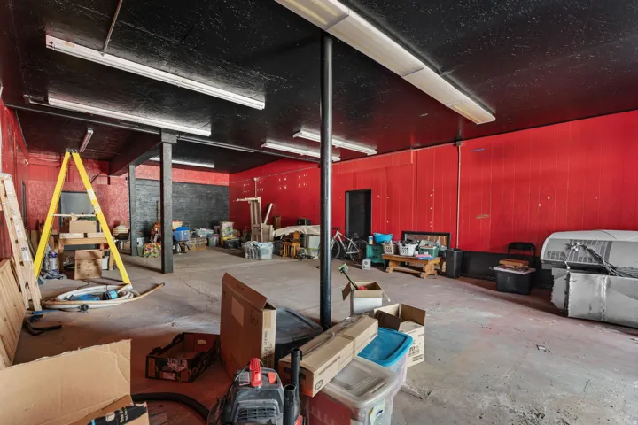 This image shows an unfinished or under-renovation commercial or industrial space with exposed structural elements, construction materials, and equipment present throughout