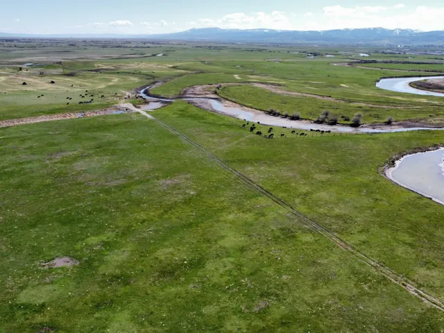 Aerial view of property and surrounding area with a mountainous background and rural landscape
