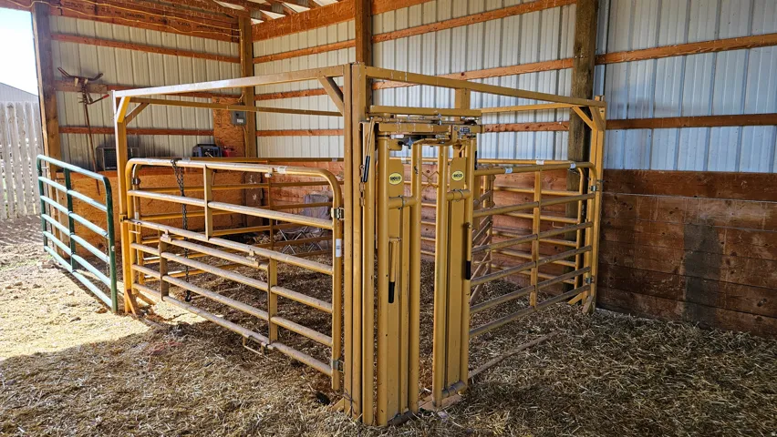 Open-sided barn structure featuring wood posts, metal siding, and a slatted wood wall