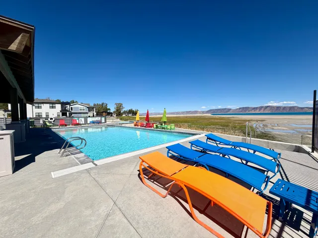 Outdoor swimming pool with integrated steps, concrete surround, and mountain backdrop