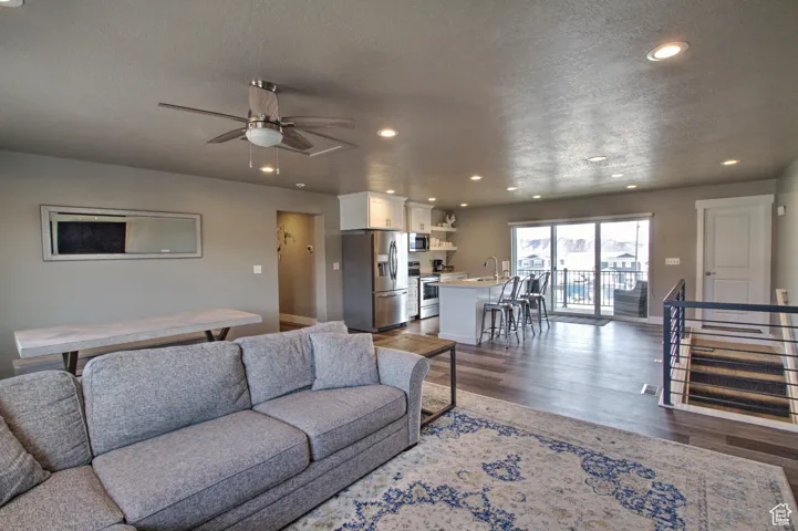 Living room with recessed lighting, a textured ceiling, dark wood-style floors, and a ceiling fan