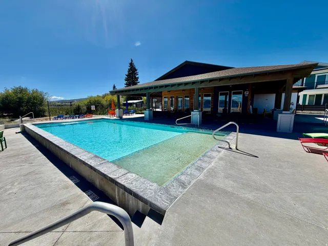 Outdoor swimming pool with integrated spa and surrounding concrete decking