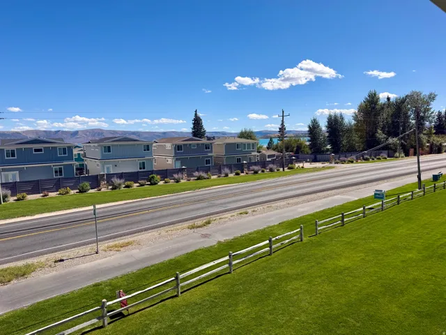 Manicured green lawn with a split rail fence and distant mountain scenery