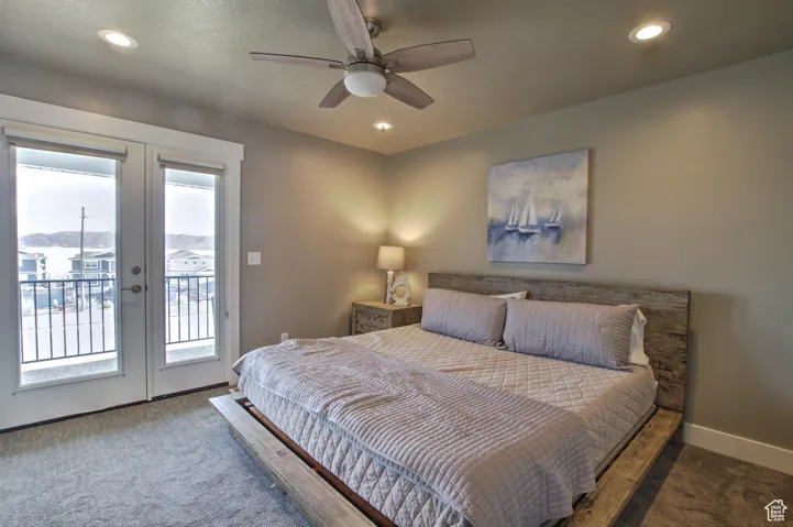 primary bedroom opens to covered deck. Carpeted bedroom with baseboards, recessed lighting, ceiling fan, french doors, and access to outside