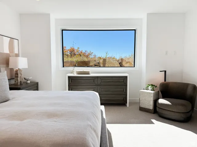 Carpeted bedroom featuring multiple windows