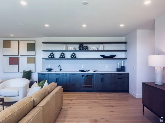 Bar area with open shelves, modern cabinets, light countertops, recessed lighting, and light wood-style flooring