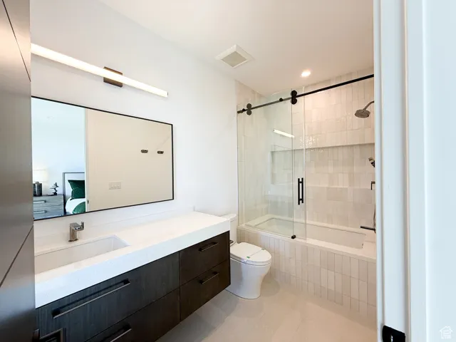 Bathroom featuring vanity, recessed lighting, tiled shower / bath combo, light tile patterned floors, and connected bathroom