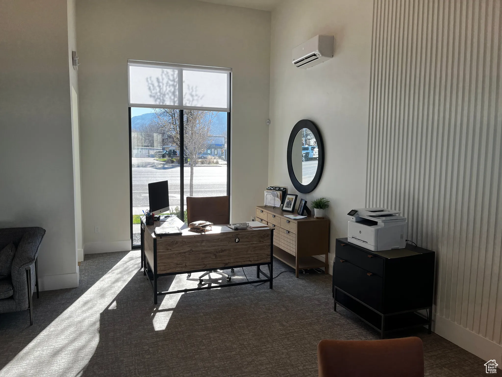 Home office featuring a wall mounted air conditioner, carpet floors, and baseboards