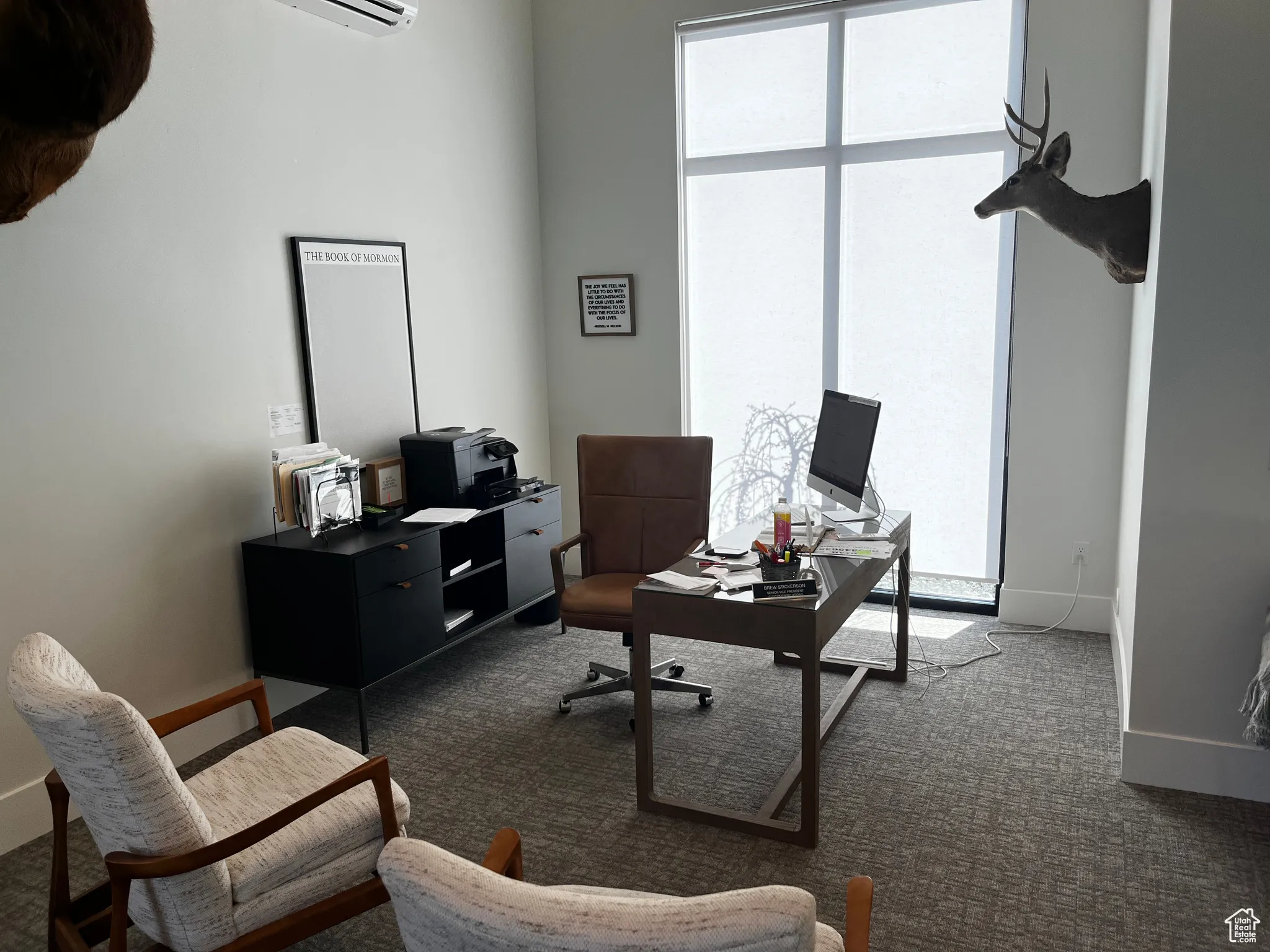 Office area featuring baseboards, a healthy amount of sunlight, an AC wall unit, and dark carpet